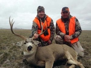 Happy hunters with a good South Dakota mule deer