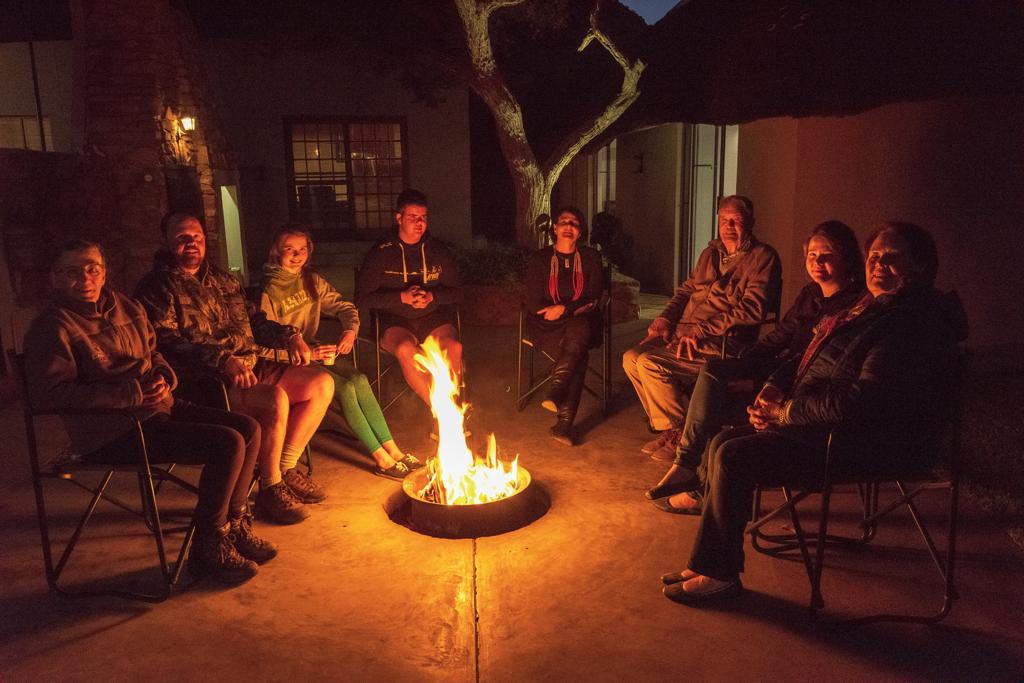 Hunters telling stories and drinking cocktails around the campfire.